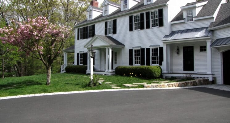 front exterior of the house with white siding and black shutters